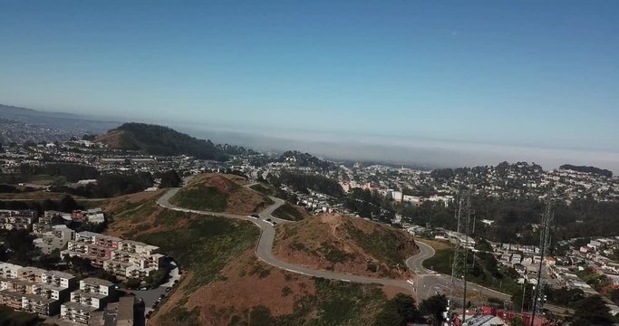 twin peaks mountains san francisco aerial shot fog network towers pan left moon in daylight