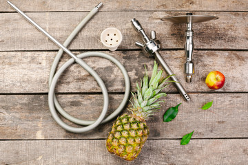 Parts of hookah and fruits on wooden background