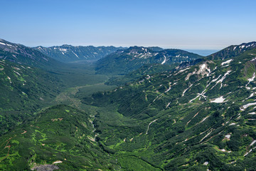 Panoramic view of the city Petropavlovsk-Kamchatsky and volcanoes: Koryaksky Volcano, Avacha Volcano, Kozelsky Volcano. Russian Far East, Kamchatka Peninsula.