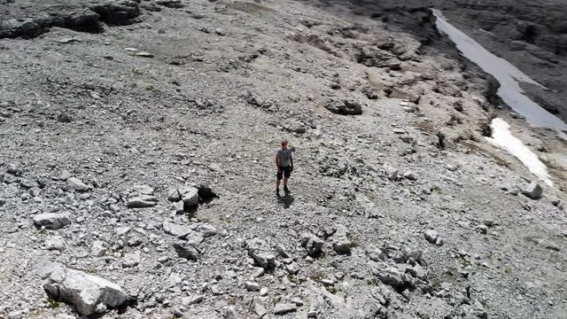 un vol autour d'une personne situ&eacute;e dans un d&eacute;cors lunaire de montagne