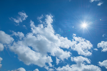 Beautiful sun star with white clouds on a blue sky