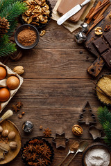 Christmas or new year culinary rustic wooden background with food ingredients for cooking festive dishes, xmas baking. Holiday cooking frame for Noel pastry on wooden table