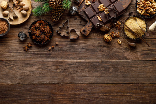 Christmas or new year culinary rustic wooden background with food ingredients for cooking festive dishes, xmas baking. Holiday cooking frame for Noel pastry on wooden table