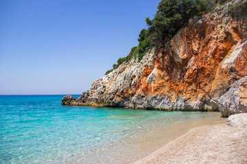 Fototapeta na wymiar Beautiful beach with rock, stones, sand, and clear turquoise water. Gjipe beach, Albania