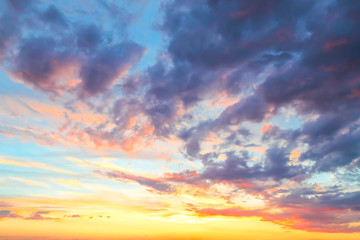 Heavenly summer background. Beautiful bright majestic dramatic evening sky at sunset or sunrise orange and blue with rays. The sun shines over the horizon against the backdrop of thunder clouds