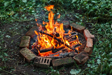 Bonfire in circle made of red bricks, top angle view