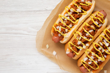 Homemade Detroit style chili dog on parchment, view from above. Top view, overhead, flat lay. Copy space.