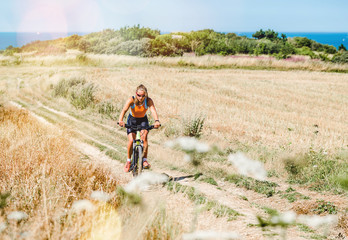 pretty young woman doing mountain bike in the summer sun