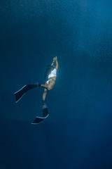 Obraz na płótnie Canvas Woman in a sexy bikini enjoys diving with a massive school of sardines in Moalboal, Cebu.