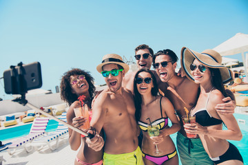 Six friends hanging out enjoying best company drinking ice cocktails making selfies