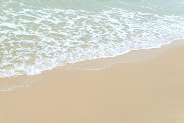 Fototapeta na wymiar Soft wave at the sea on the sandy beach. Background