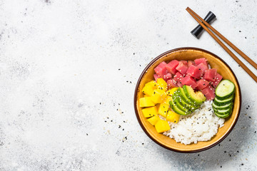 Fototapeta na wymiar Tuna poke bowl with rice, avocado, mango and cucumber on white table.