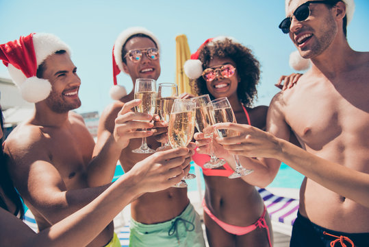 Portrait Of Cheerful Crowd Of Students Toasting Wearing Santa Claus Hat Eyewear Eyeglasses Having Brunet Hair Standing Outside