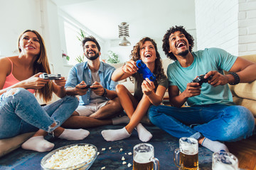 Group of friends play video games together at home, having fun.