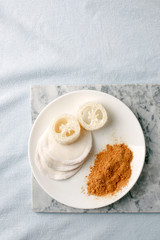 Eco friendly products for home cleaning, zero waste lifestyle, flat lay on white background. Mustard and natural luffa sponge on white plate, stylish minimalism