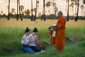 Women make merit with monk in rural areas according to the beliefs of Buddhism in Thailand