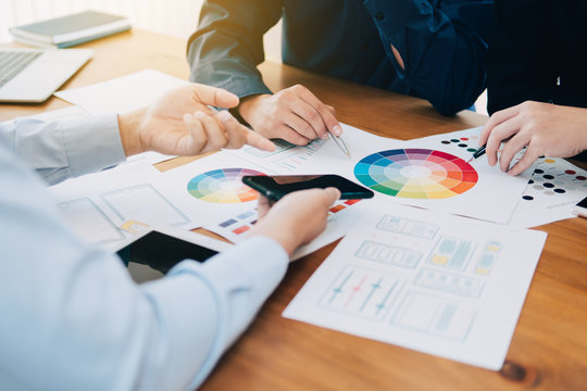 Creative UI designer teamwork meeting planning designing layout application mockup on smartphone screen