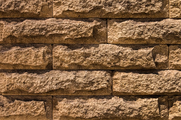 Wall of brown natural stone blocks