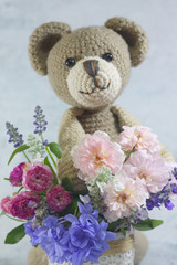 Teddy bear doll with flower bouquet