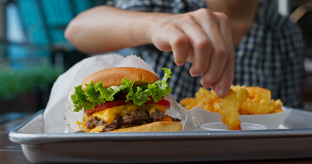 Woman enjoy burger and french fries
