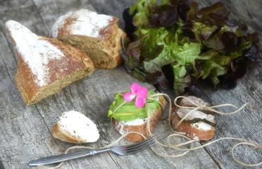 Plain sandwiches with baked meat and avocados on a rough wooden background. Simple farm food.