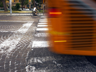 yellow city bus passing pedestian cross