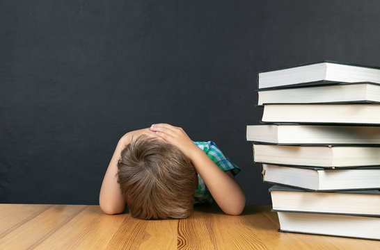 Back to schhol concept - depressed boy in front of blackboard, copy space