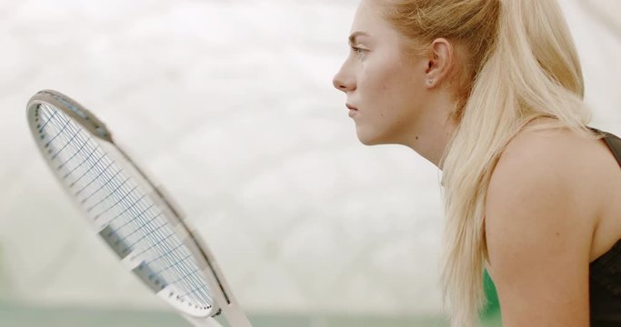 CU Portrait of focused young Caucasian female tennis player preparing for a serve. 120 FPS slow motion, 4K UHD RAW graded footage
