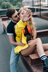 attractive and blonde woman showing hand and handsome man hugging her