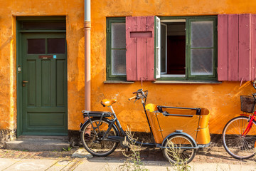 Fototapeta na wymiar Picturesque of Copenhagen. Old yellow house of Nyboder district with bikes. Old Medieval district in Copenhagen, Denmark