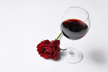 Wine glass and beautiful red rose isolated on white background