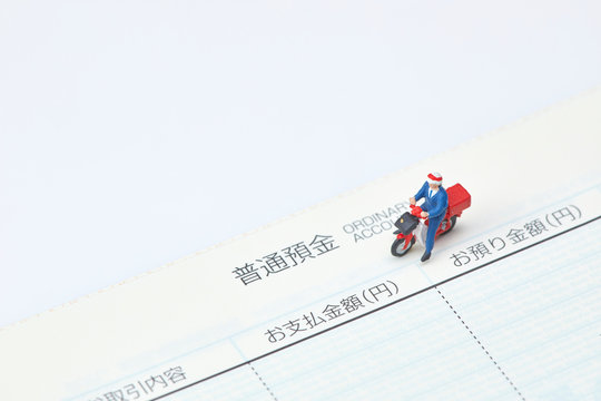 ミニチュア人形を使った郵便配達と料金のイメージ