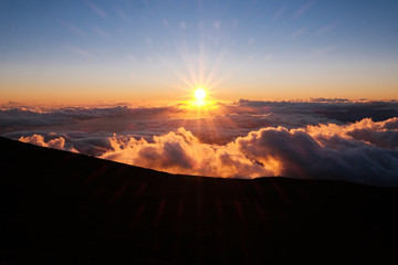 sunset on a mountain above the clouds