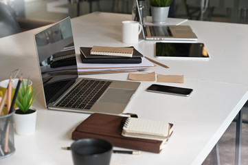 Mockup laptop computer on conference table in meeting room.