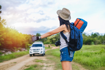 Asia woman traveler hitchhike for go to destination in her trip.