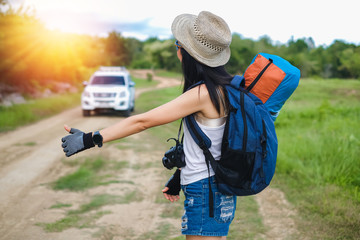 Asia woman traveler hitchhike for go to destination in her trip.