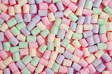 Colorful mini marshmallows on pink background