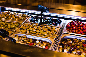 Green, red, black olives stuffed in containers