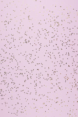 Golden sparkles stars on pink pastel trendy background. Festive background. Flat lay, top view