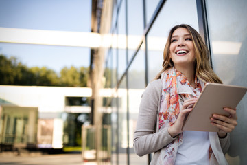 Beautiful young woman using tablet in the city
