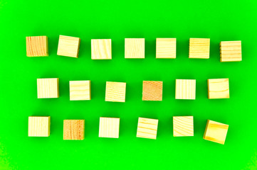 wooden cubes on green background, three rows of wooden cubes for your advertising slogan on green background