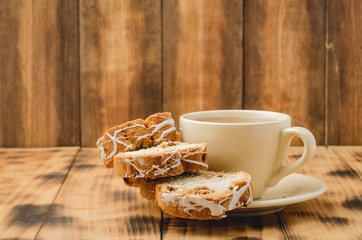 Tea cup and pastries piece on wooden table. Breakfast.