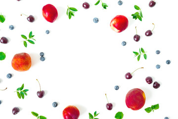 Peaches with cherry and blueberries on white background. Summer food frame. Top view. Flat lay