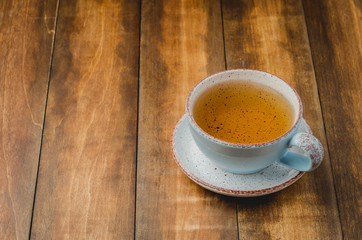 Blue cup of tea on wooden background, selective focus and copyspace for text