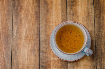 Blue cup of tea on wooden background, top view and copyspace for text