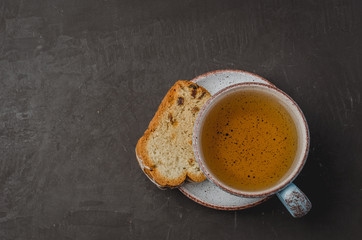 Tea cup and pastries piece on stone table. Breakfast. Top view