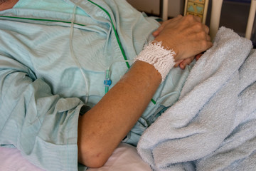 病院のベッドで点滴を受ける男性