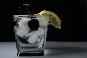 стакан со льдом, лимоном и черешней