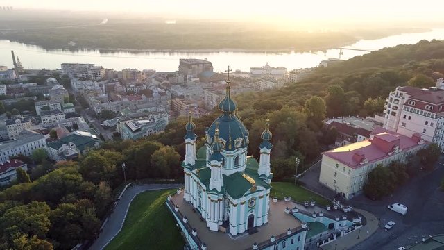 Flying above and around St. Andrew's Church in Kyiv, Ukraine at sunrise. The church is now belongs to Orthodox Ecumenical Patriarchate of Constantinople. Podil District and Dnieper River are in the