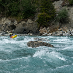 kayaker passing through rapids on a wild mountain river